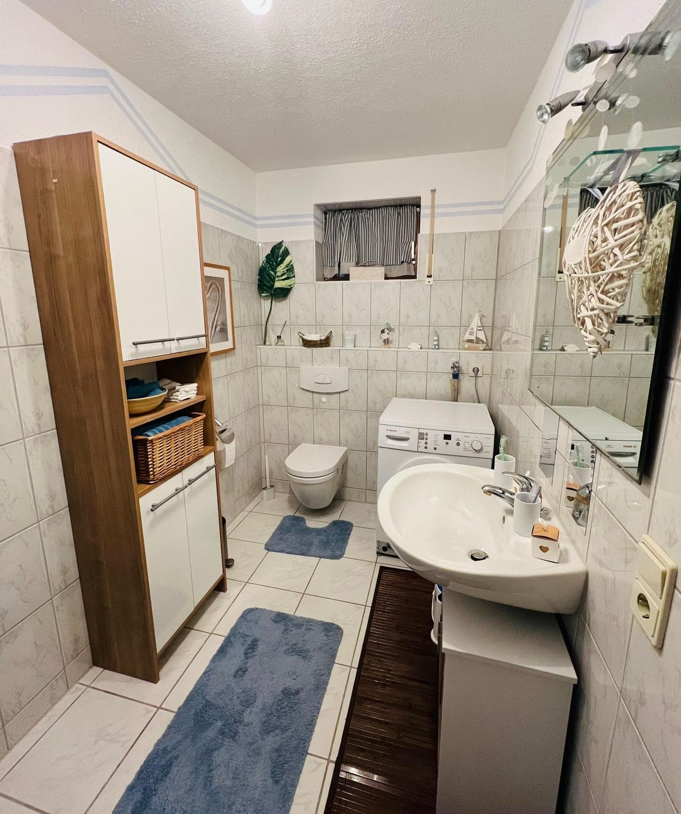 Badezimmer mit WC, Waschmaschine und Waschbecken