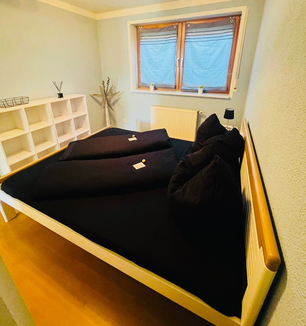 Schlafzimmer mit Doppelbett und offenen Regalen